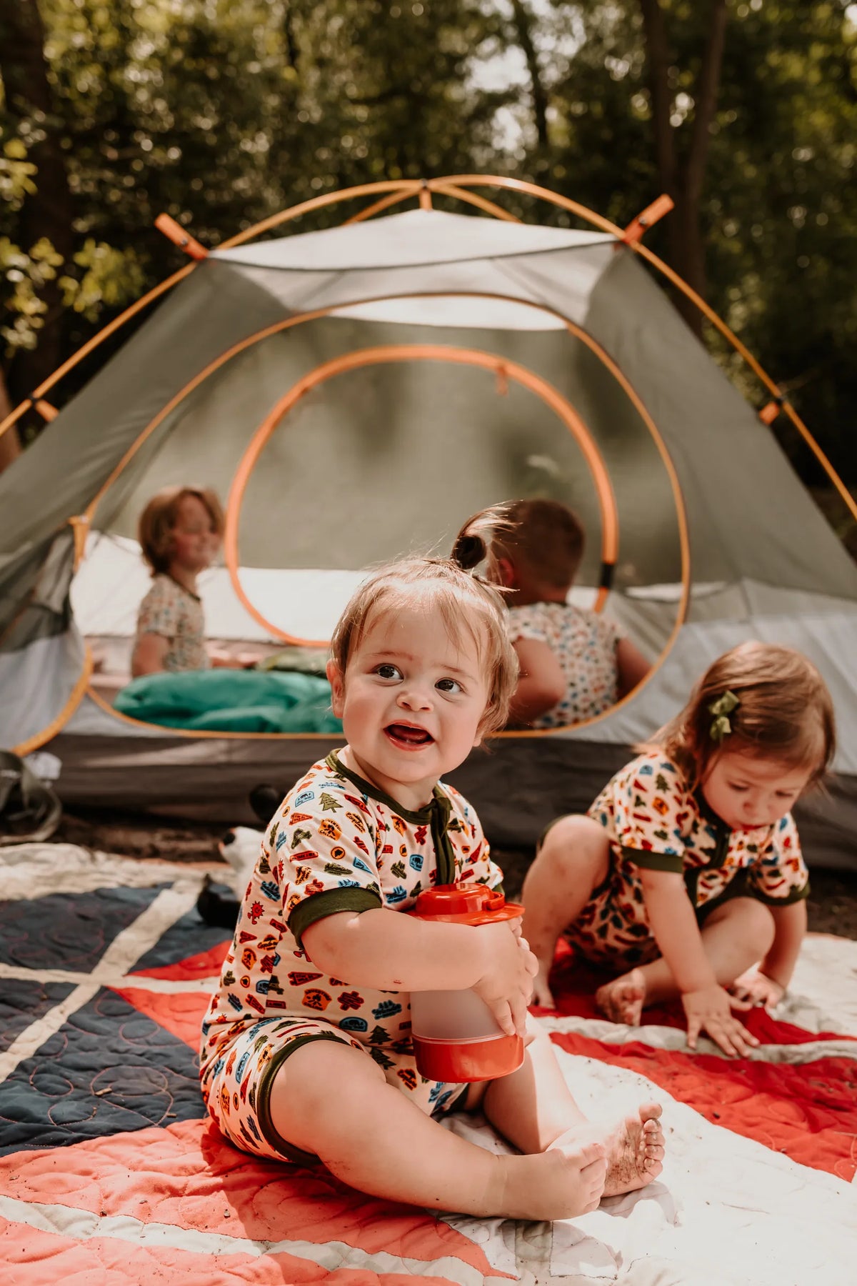 Baby wearing the Summer Camp Onesie at the tent